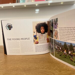 May include: An open book with a colourful illustration of a young girl holding a drawing. The book has the title "The Young People" and text about the importance of giving Black youth a voice.