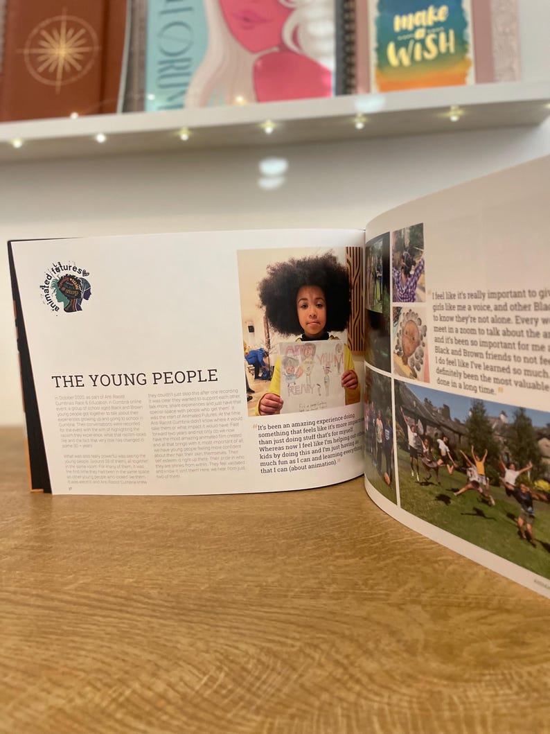 May include: An open book with a colourful illustration of a young girl holding a drawing. The book has the title "The Young People" and text about the importance of giving Black youth a voice.