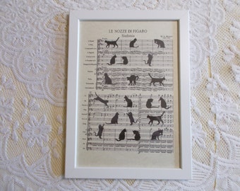 White wood frame with cats walking on a Mozart music score The Marriage of Figaro