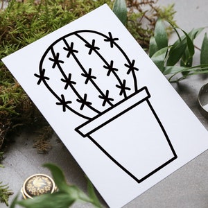 Op de afbeelding: Een zwart-witte lijntekening van een cactus in een pot. De cactus heeft een ronde vorm met veel stekels en staat in een eenvoudige pot.
