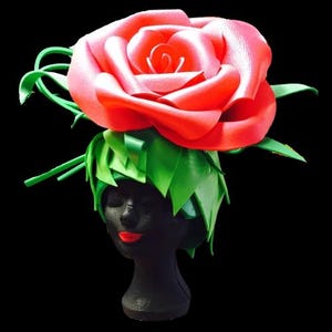 May include: A large red foam rose with green foam leaves, worn as a hat.