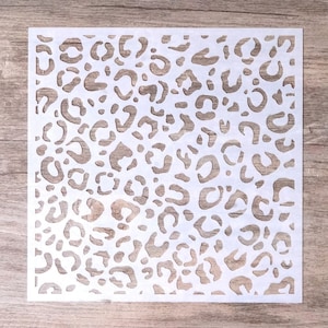 Pode incluir: Estêncil de plástico branco com um design de estampa de leopardo. O estêncil é feito de um material fino e flexível, ideal para criar uma variedade de artesanato.