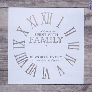 May include: White stencil with a clock face design. The clock face has Roman numerals and the text "time spent with family is worth every minute".
