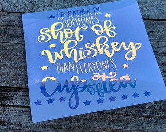 May include: A blue background with a gold and white vinyl decal that reads "I'd rather be someone's shot of whiskey than everyone's cup of tea".