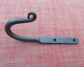 May include: A black metal hook with a curved top and a flat base. The base has three holes for mounting.