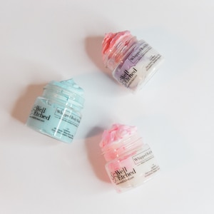 Pu&ograve; includere: Tre barattoli di burro corporeo montato in diversi colori: azzurro, rosa e viola. Ogni barattolo ha un'etichetta bianca con il testo "Well Etched" e "Whipped Body Butter".
