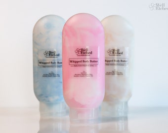 May include: Three plastic bottles of whipped body butter with swirl designs. The bottles are labeled "Whipped Body Butter" and "Well Etched".