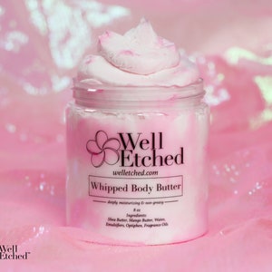 May include: A pink jar of whipped body butter with the brand name "Well Etched" and the text "Whipped Body Butter - deeply moisturizing & non-greasy - 8 oz. Ingredients: Shea Butter, Mango Butter, Water, Emulsifiers, Optiphen, Fragrance Oils" on the label.