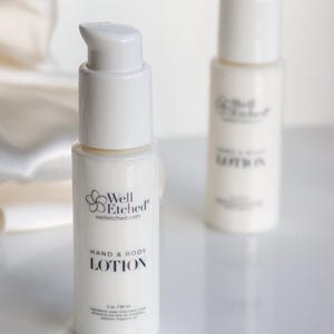 May include: Two white hand and body lotion bottles with pump dispensers. The front bottle displays the text "Well Etched" and "HAND & BODY LOTION". Each bottle contains 2 oz / 59 ml of lotion.