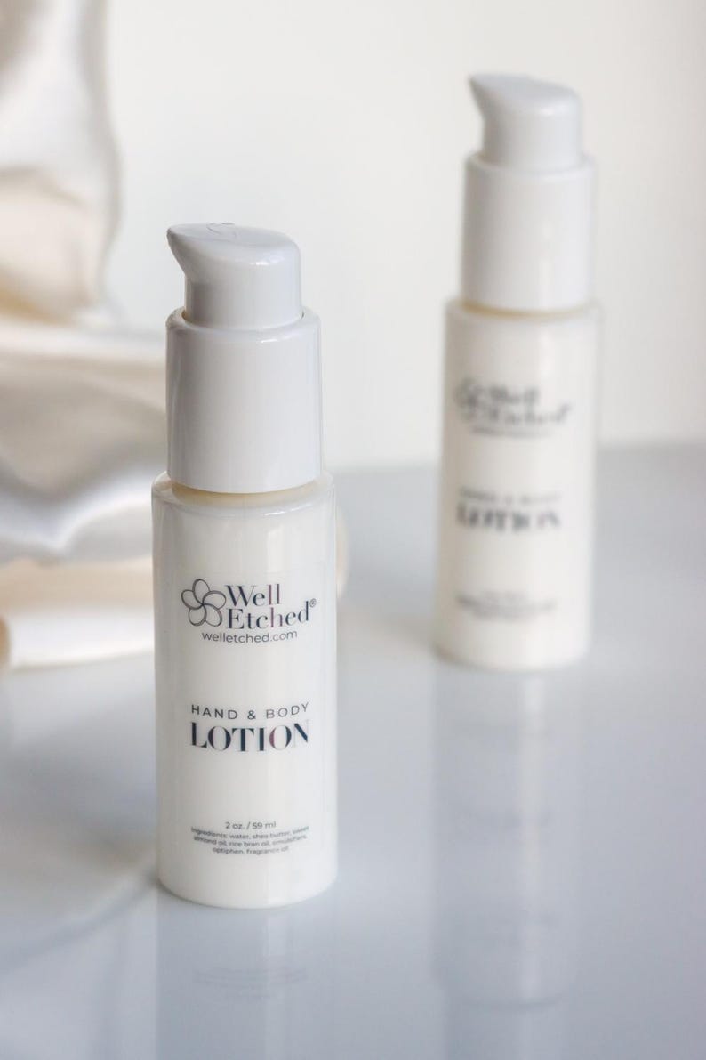 May include: Two white hand and body lotion bottles with pump dispensers. The front bottle displays the text "Well Etched" and "HAND & BODY LOTION". Each bottle contains 2 oz / 59 ml of lotion.