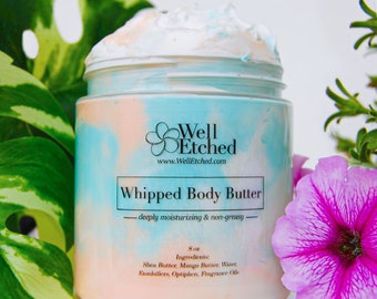 May include: A 8 ounce jar of whipped body butter with a blue and pink swirl design. The jar has a black label with the text "Well Etched" and "Whipped Body Butter - deeply moisturizing & non-greasy" on it. The ingredients are listed on the label: Shea Butter, Mango Butter, Water, Emulsifiers, Optiphen, Fragrance Oils.