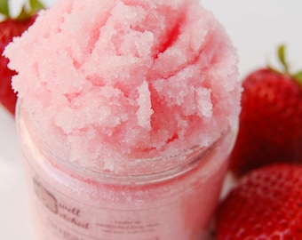 May include: Pink sugar scrub in a glass jar with a white label that says "well etched sugar scrub". The jar is surrounded by fresh strawberries.