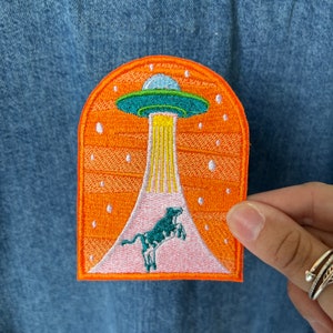 Orange Alien UFO Cow Abducted, UAP, Embroidered Iron on or Sew on Patch for bags, denim jackets, hats, jeans