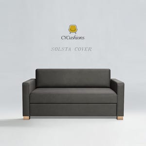 Puede incluir: Un sofá SOLSTA COVER gris oscuro con un diseño moderno. El sofá tiene forma rectangular con respaldo bajo y reposabrazos. El sofá se apoya en cuatro patas de madera. El texto "CYCushions" y "SOLSTA COVER" se muestra encima del sofá.