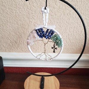 Könnte beinhalten: Ein weißer, drahtumwickelter Lebensbaum mit rosa, blauen und grünen Kristallen, die an den Ästen hängen. Der Baum steht auf einem schwarzen Metallständer mit einer Holzbasis.