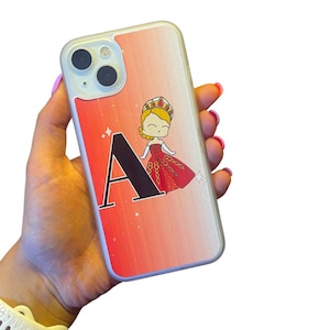 Puede incluir: Una funda de teléfono transparente con un fondo de brillo degradado rojo y naranja. La funda presenta una letra "A" negra y una princesa de dibujos animados con un vestido rojo y una corona.