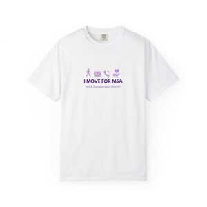 Puede incluir: Camiseta blanca con cuello redondo y mangas cortas. La camiseta presenta un gráfico morado con iconos y el texto "I MOVE FOR MSA" y "MSA Awareness Month". La camiseta está hecha de un material suave y cómodo.