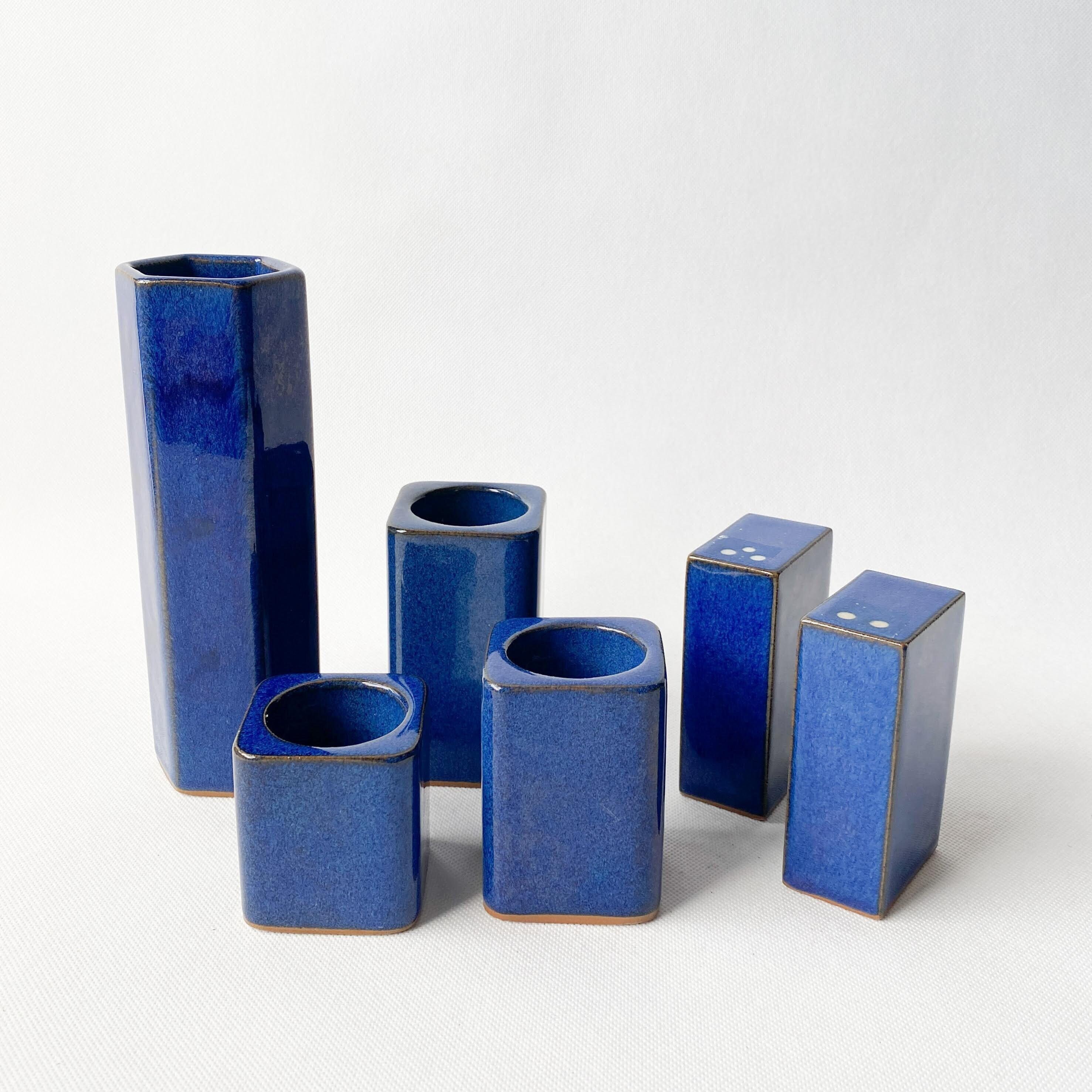 ensemble de vaisselle six pièces en céramique émaillée bleue. vase, bougies chauffe-plat et salière poivrière. lignes minimalistes. cadeau