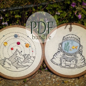Könnte beinhalten: Zwei Stickmuster auf Stickrahmen, eines mit einer Bergkette und Planeten, das andere mit einem Astronauten mit einem Fisch in seinem Helm. Der Text "PDF bundle" ist auf dem Bild gedruckt.