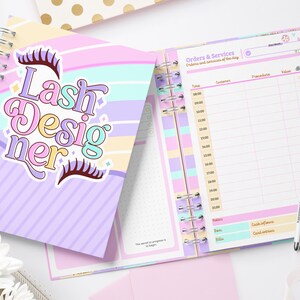 Könnte beinhalten: Ein spiralgebundenes Notizbuch mit pastellfarbenem Einband mit dem Text "Lash Designer" und Wimperngrafiken. Das offene Notizbuch zeigt ein Tagesplaner-Layout mit Zeitfenstern und Abschnitten für Notizen und Dienstleistungen.