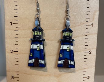 May include: A pair of blue and white lighthouse earrings with silver hooks. The earrings are about 2 inches long.