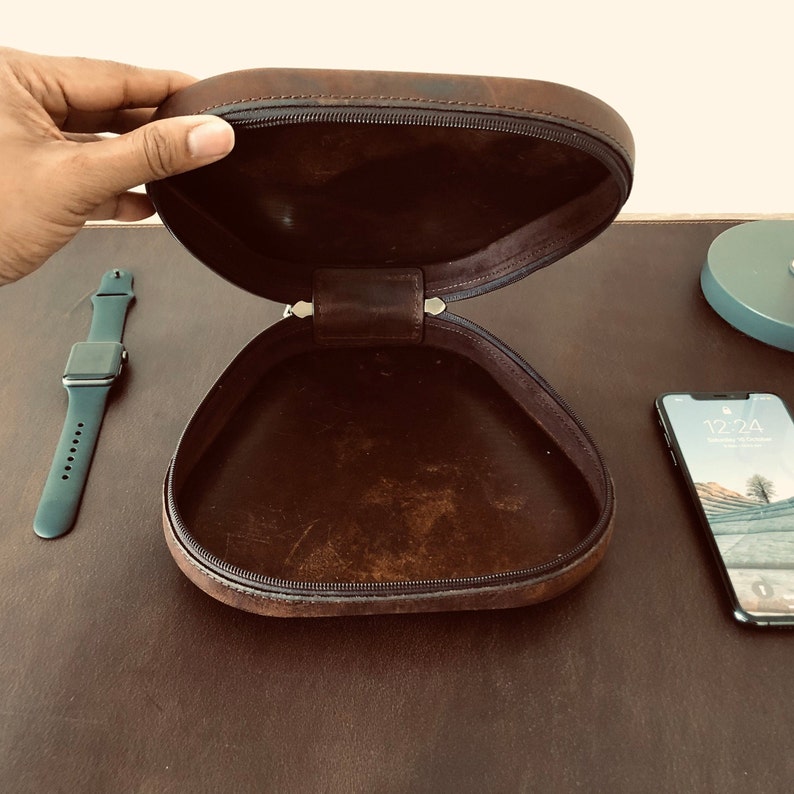 May include: A brown leather case with a zipper closure. The case is open and empty.