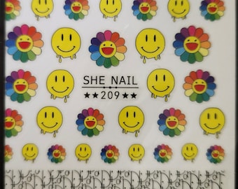 May include: A sheet of colorful nail stickers featuring a smiling face with a flower design. The stickers are arranged in rows and columns on a white background. The text "SHE NAIL ★★209★★" is printed at the top of the sheet.