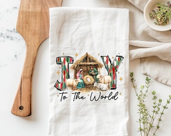 May include: White kitchen towel with a colorful "JOY" design featuring a nativity scene with the words "To the World" below.