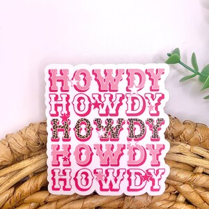 May include: Pink and white sticker with the word "Howdy" repeated five times in a stacked design. Each word has a different design, with some featuring leopard print and stars.