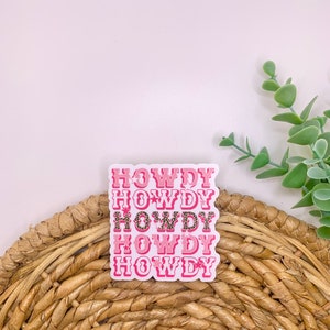 May include: Pink and white sticker with the word "HOWDY" repeated five times. The sticker has a pink and white leopard print design.
