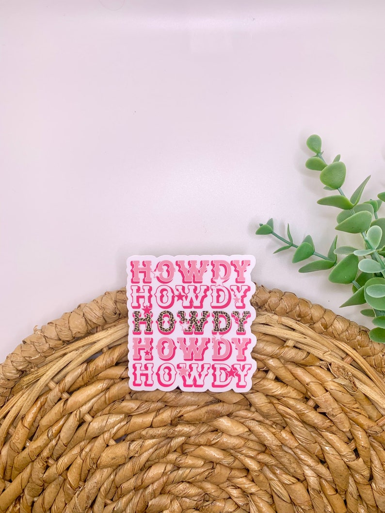 May include: Pink and white sticker with the word "HOWDY" repeated five times. The sticker has a pink and white leopard print design.