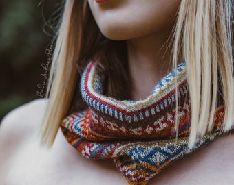 May include: A close-up of a woman's face with bright red lipstick. She is wearing a colorful knitted scarf with a brown cord.