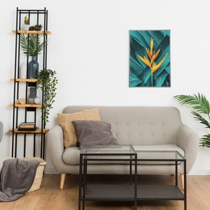 Puede incluir: Un dise&ntilde;o de interior de sala de estar con un sof&aacute; gris, una estanter&iacute;a de escalera de metal negro, una silla gris, una mesa de caf&eacute; de vidrio y una planta tropical en una maceta de terracota. Una impresi&oacute;n enmarcada de una flor tropical con hojas verdes cuelga de la pared.
