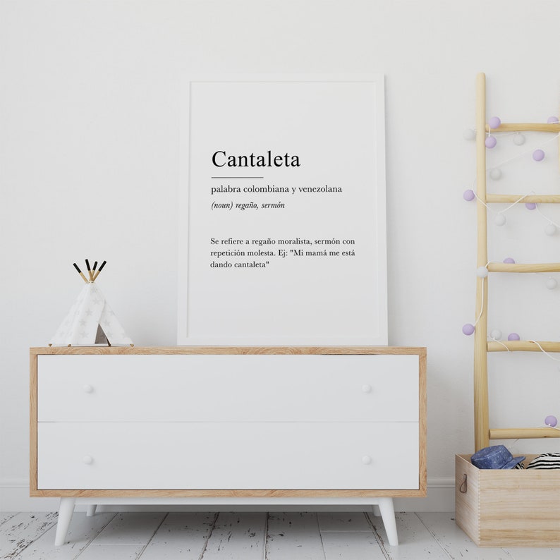 May include: A white framed print with the word "Cantaleta" in black text. The definition of the word is in Spanish and reads "palabra colombiana y venezolana (noun) rega&ntilde;o, serm&oacute;n Se refiere a rega&ntilde;o moralista, serm&oacute;n con repetici&oacute;n molesta. Ej: "Mi mam&aacute; me est&aacute; dando cantaleta"