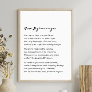 Könnte beinhalten: Gerahmter Druck mit den Worten "New Beginnings" in eleganter Schrift. Der Druck zeigt ein Gedicht über Neuanfänge, Wachstum und den Lauf der Zeit, vor einem weißen Hintergrund. Der Rahmen hat eine helle Holzfarbe.