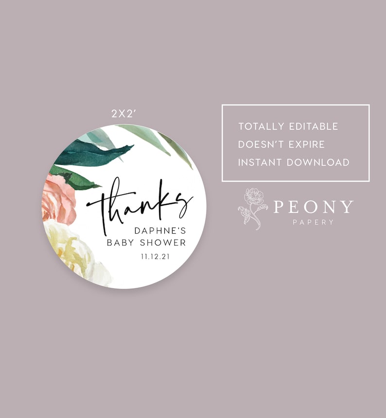 May include: A round, 2-inch thank you sticker with a floral design in shades of pink, white, and green. The text "Thanks" is written in black cursive script. The text "Daphne's Baby Shower 11.12.21" is written in black sans-serif font.
