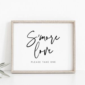 May include: A framed print with the text "S'more love" in black cursive font. Below the text is the phrase "Please take one" in a smaller font.
