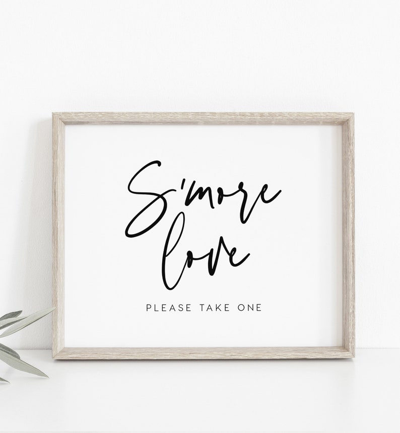 May include: A framed print with the text "S'more love" in black cursive font. Below the text is the phrase "Please take one" in a smaller font.