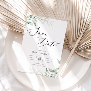 Op de afbeelding: Save the Date huwelijksuitnodiging met groene aquarelbladeren en de tekst "Save the Date" voor het huwelijk van Elise en William op zaterdag 26 augustus 2021 in Melbourne, Victoria. Formele uitnodiging volgt.