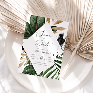 Op de afbeelding: Save the Date huwelijksuitnodiging met tropische bladeren en zwarte en gouden accenten. De uitnodiging luidt "Save the Date" voor het huwelijk van Elise en William op zaterdag 26 augustus 2021 in Melbourne, Victoria.