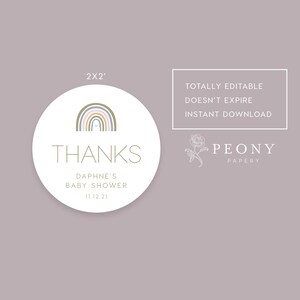 May include: A round, white sticker with a rainbow design in shades of brown, blue, and pink. The text "THANKS" is in gold lettering, followed by "DAPHNE'S BABY SHOWER 11.12.21". The sticker is 2 inches in diameter.
