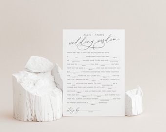 Può includere: Una carta da gioco di matrimonio in bianco e nero con il testo "Allie & Ryan's Wedding Wisdom." La carta ha un formato da compilare con suggerimenti sulla relazione della coppia.