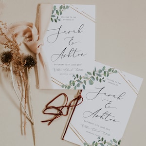 May include: Two wedding programs with the names "Sarah & Ashton" in elegant script. The programs feature eucalyptus and gold geometric accents. The date "Saturday 16th June 2019" is printed below the names. A ribbon and dried flowers are also present.