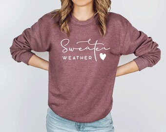 May include: A maroon sweatshirt with the text "Sweater Weather" and a small white heart.