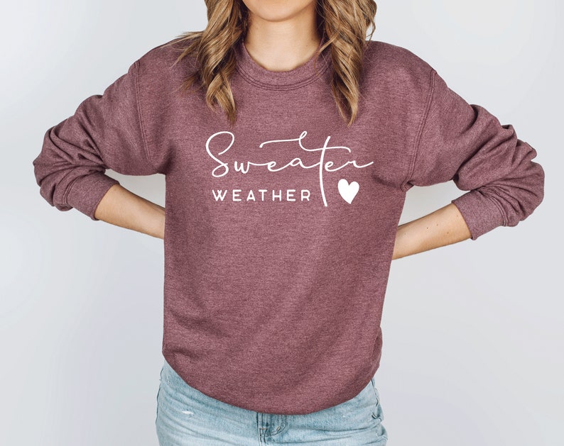 May include: A maroon sweatshirt with the text "Sweater Weather" and a small white heart.