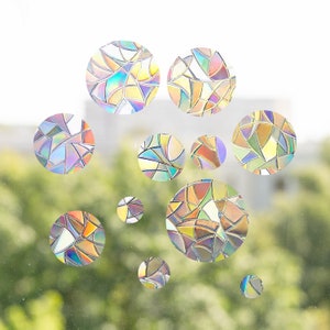 Könnte beinhalten: Eine Sammlung von Fensteraufklebern im Stil von Buntglas in verschiedenen Größen und kreisförmigen Formen. Die Aufkleber weisen ein Mosaikmuster mit einem Farbspektrum auf, darunter Blau-, Grün-, Gelb- und Orangetöne. Für Fenster.