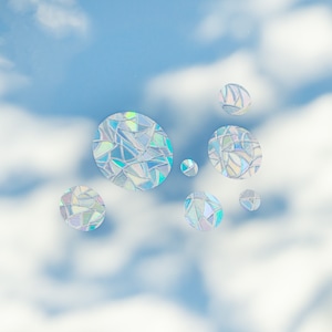 May include: Iridescent, mosaic-like circles float against a blue sky with fluffy white clouds. The circles vary in size and reflect a spectrum of colors, creating a shimmering effect. The overall theme suggests decorative elements or stickers.