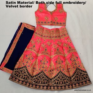 May include: A pink and blue embroidered Indian bridal outfit with a velvet border. The outfit includes a long skirt, a sleeveless blouse, and a matching dupatta.