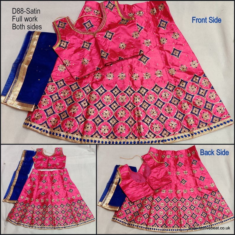 May include: A pink and blue girls' lehenga choli with gold embroidery. The skirt is a full circle skirt with a blue border. The choli is sleeveless and has a round neckline. The dupatta is a sheer blue fabric with a gold border.
