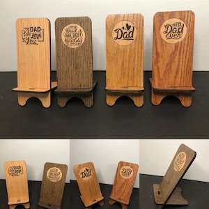 May include: Set of six wooden phone stands with different engraved messages, including "Dad", "My Best Buddy", and "Best Dad Ever".